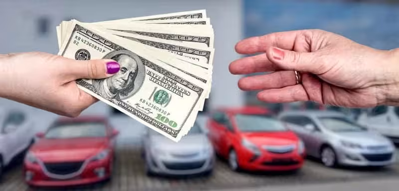 cars in the background, cash exchange between two hands